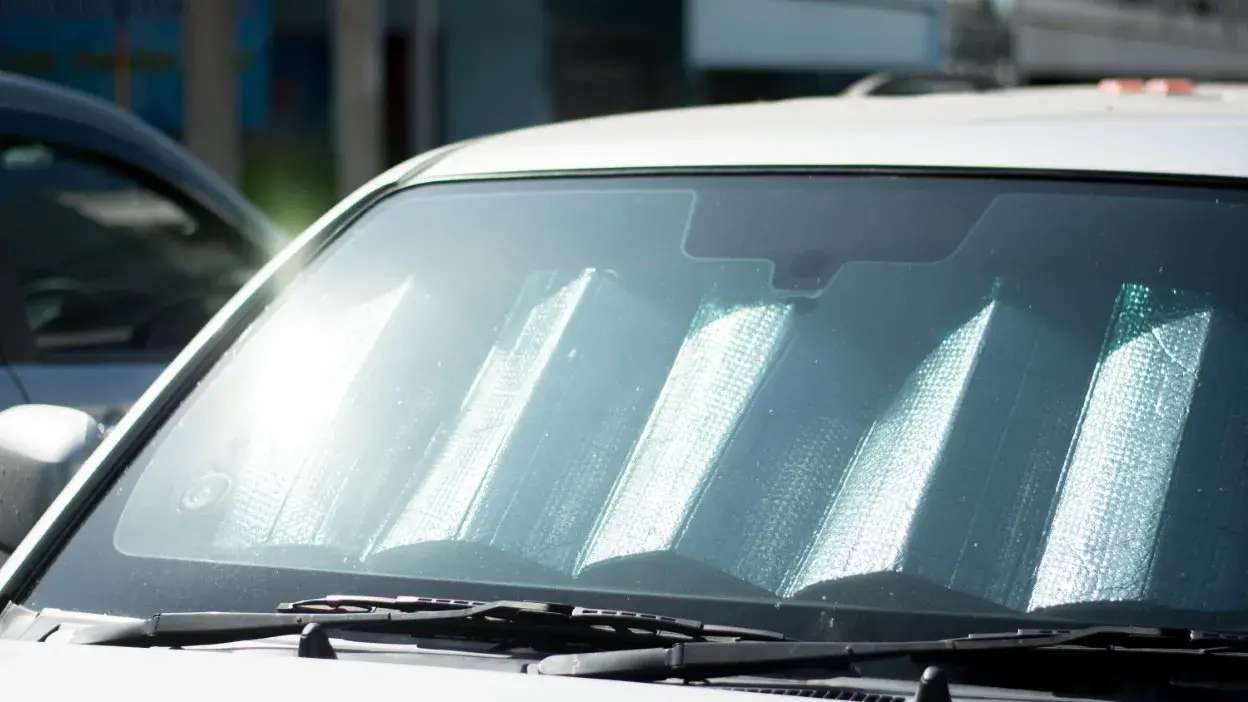 Protetor solar refletor colocado no para-brisas de um carro estacionado ao sol