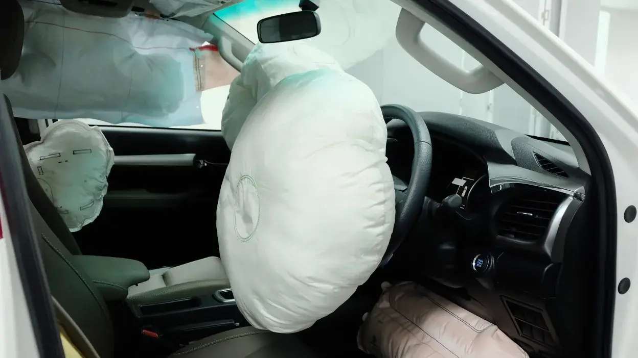 Interior de carro com airbags dianteiros e laterais acionados após colisão.