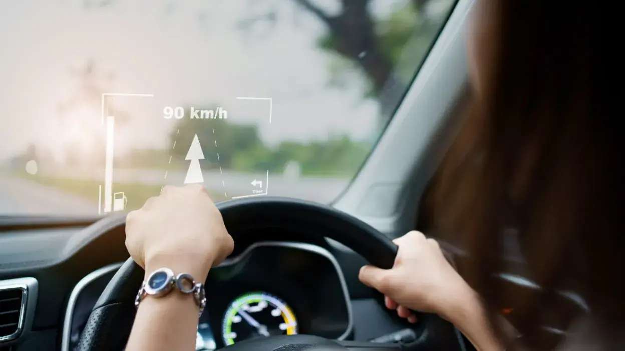 Pessoa a conduzir um carro com visor head-up a mostrar velocidade e direção