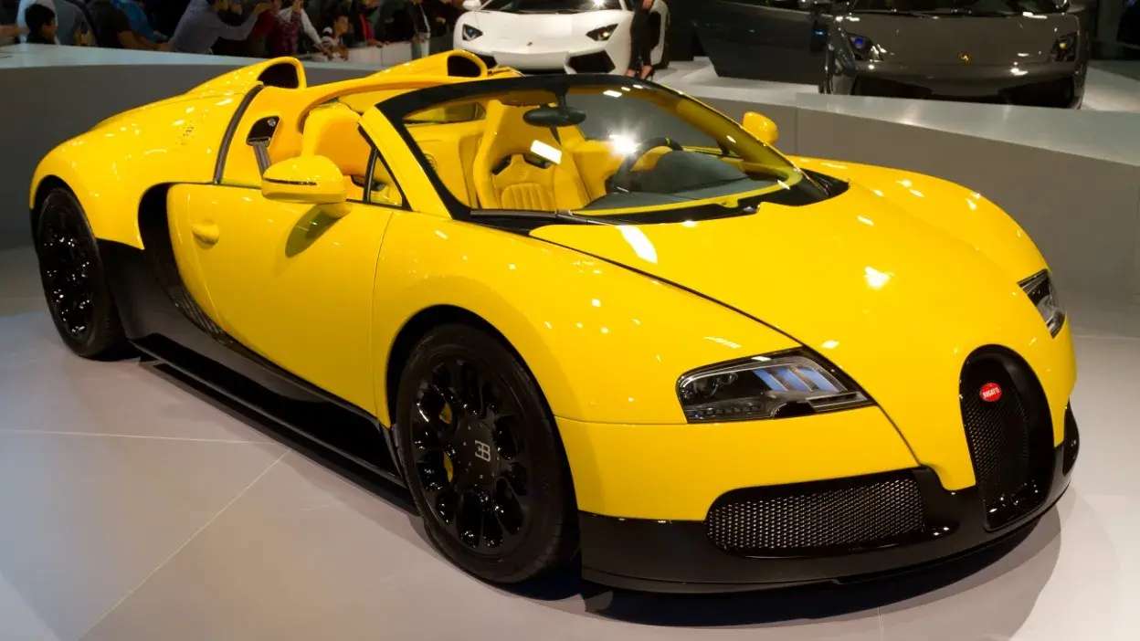 Bugatti Veyron amarelo com detalhes pretos em exposição automóvel