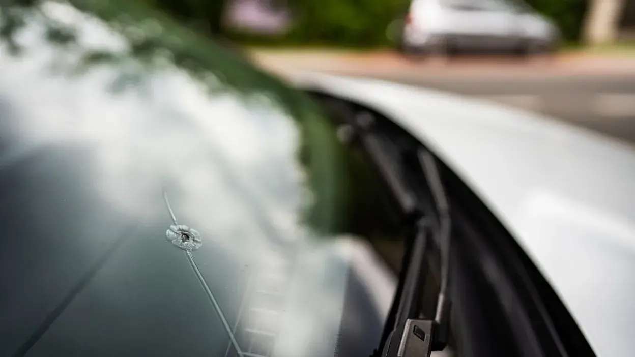 Vidro de para-brisas de carro com fissura e impacto visível