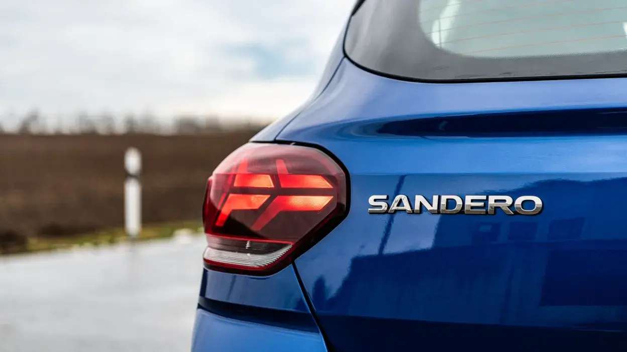 Farolim traseiro e emblema Sandero de carro azul estacionado