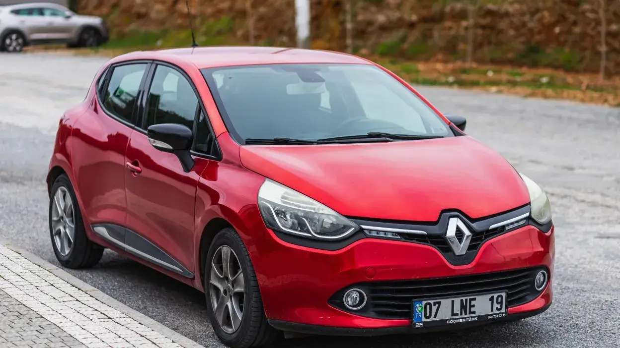 Automóvel Renault vermelho estacionado numa rua.
