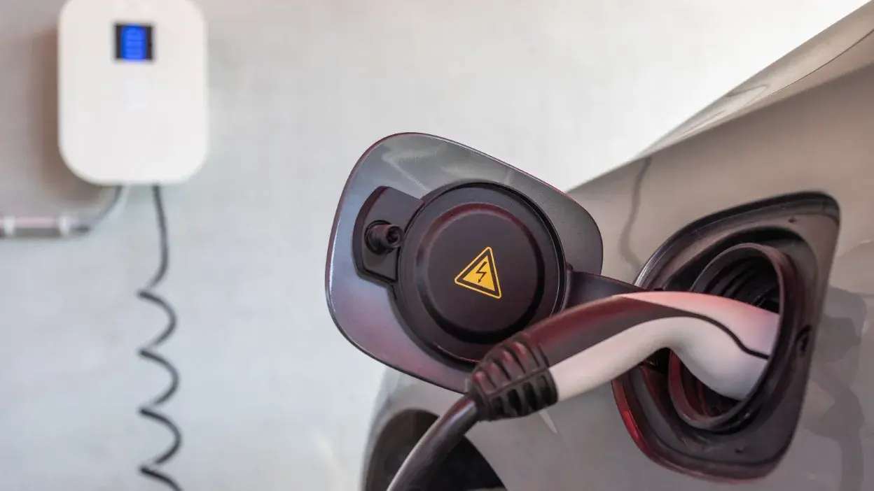 Cabo de carregamento ligado a carro elétrico com símbolo de eletricidade na tampa do depósito.