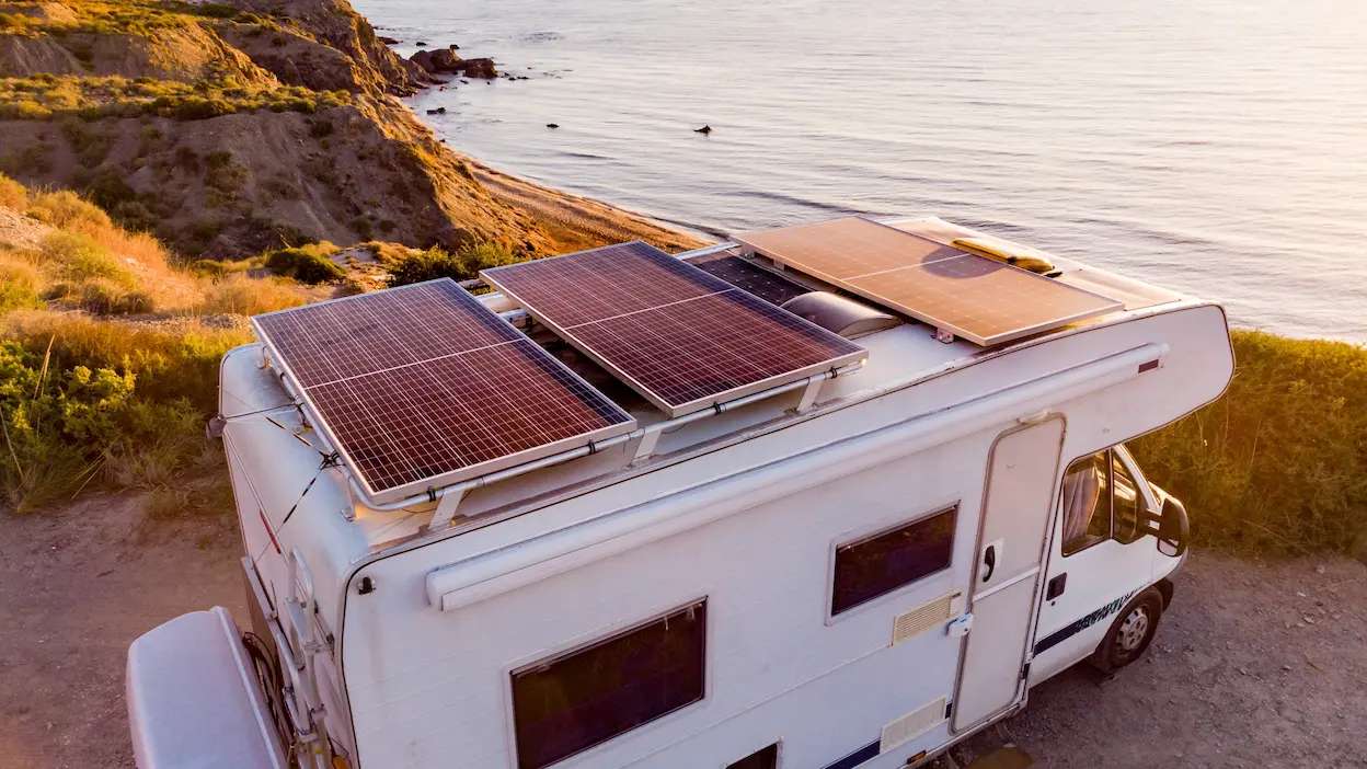 Autocaravana estacionada no topo de uma encosta com vista para o mar em Portugal