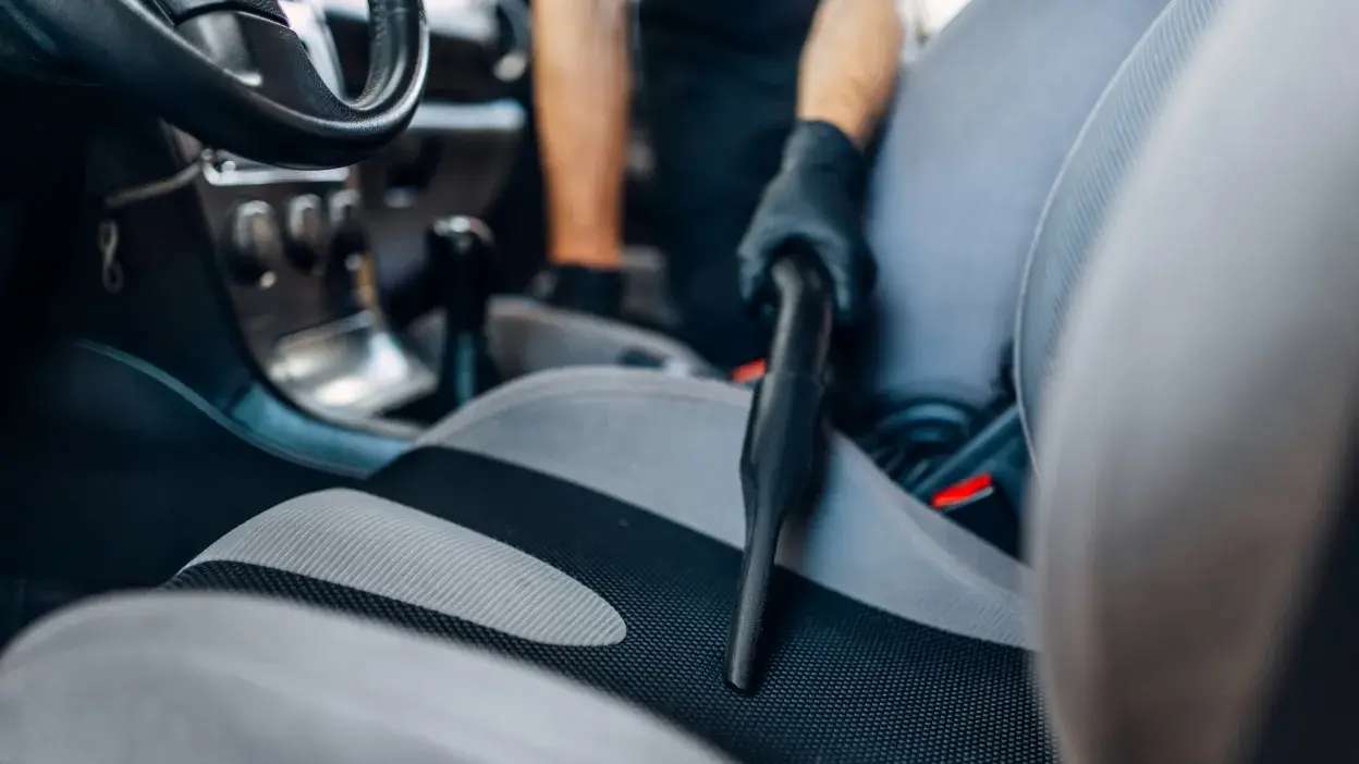 Técnico a espirar o banco da frente do carro 