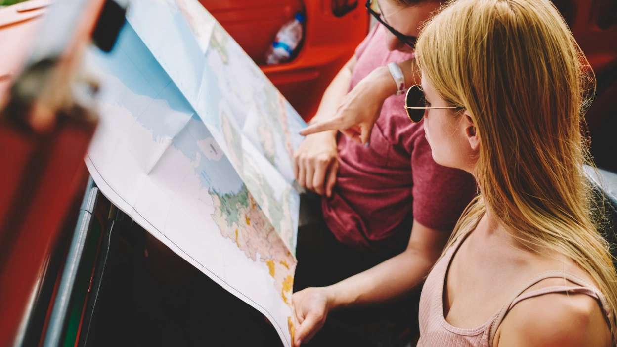 Casal a analisar atentamente um mapa