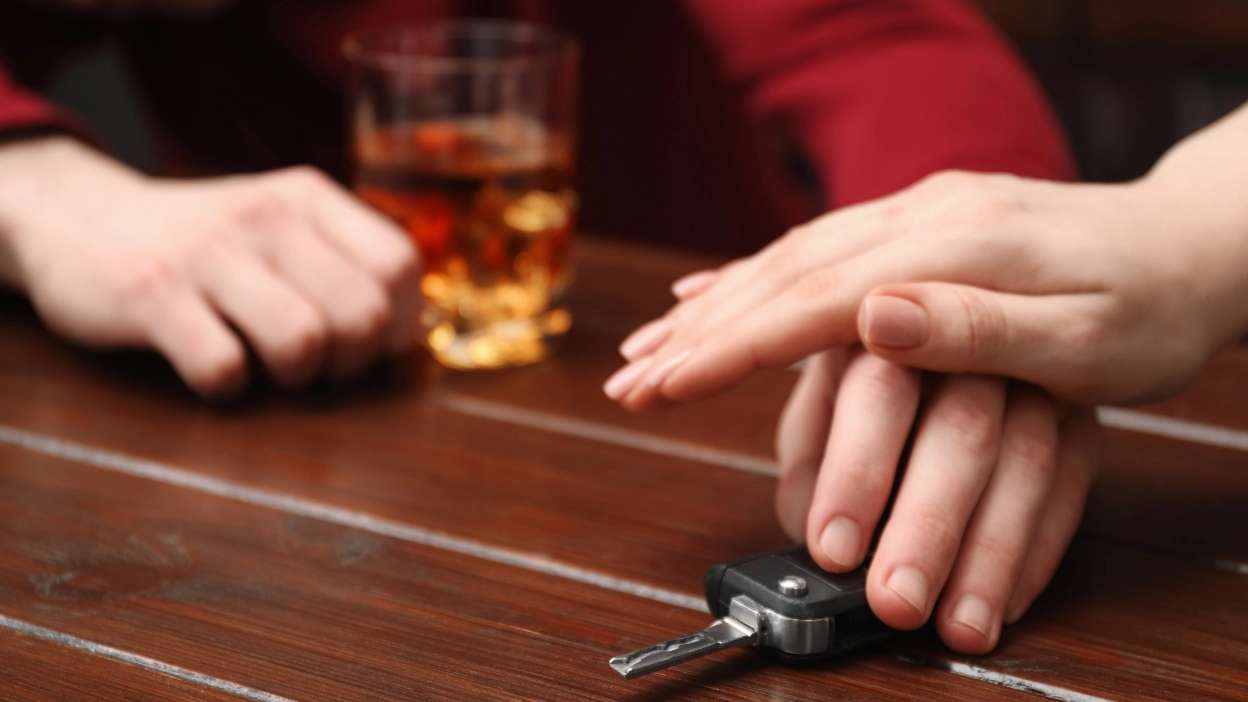 homem a impedir amigo de pegar na chave do carro para conduzir, depois de beber álcool