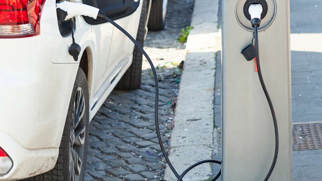 Carro elétrico branco ligado ao carregador