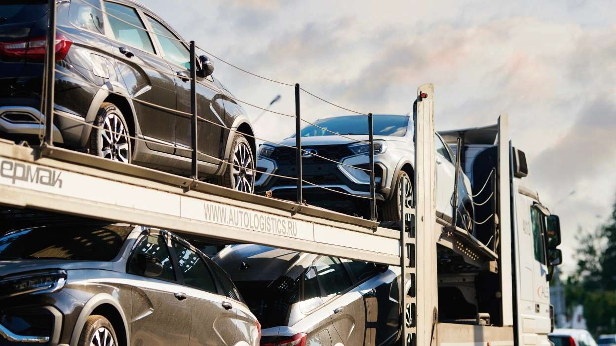 vários carros em cima de plataforma de reboque