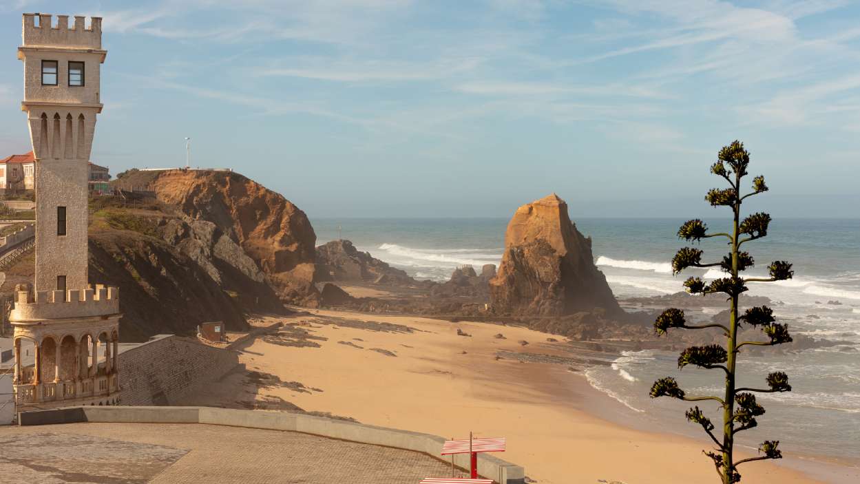 foto da praia de santa cruz, com o penedo do guincho como fundo